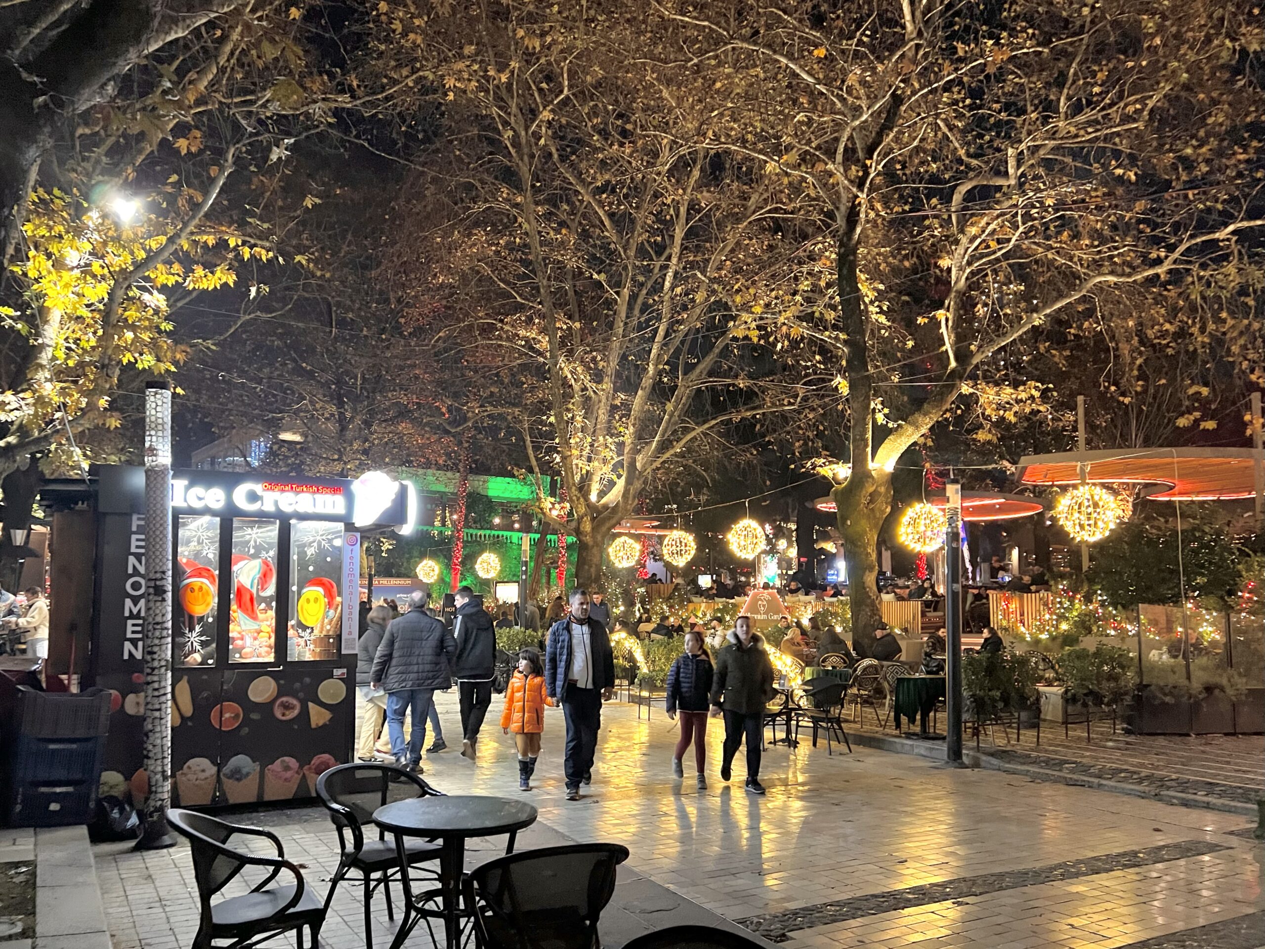 People strolling safely through well-lit streets of Tirana at night