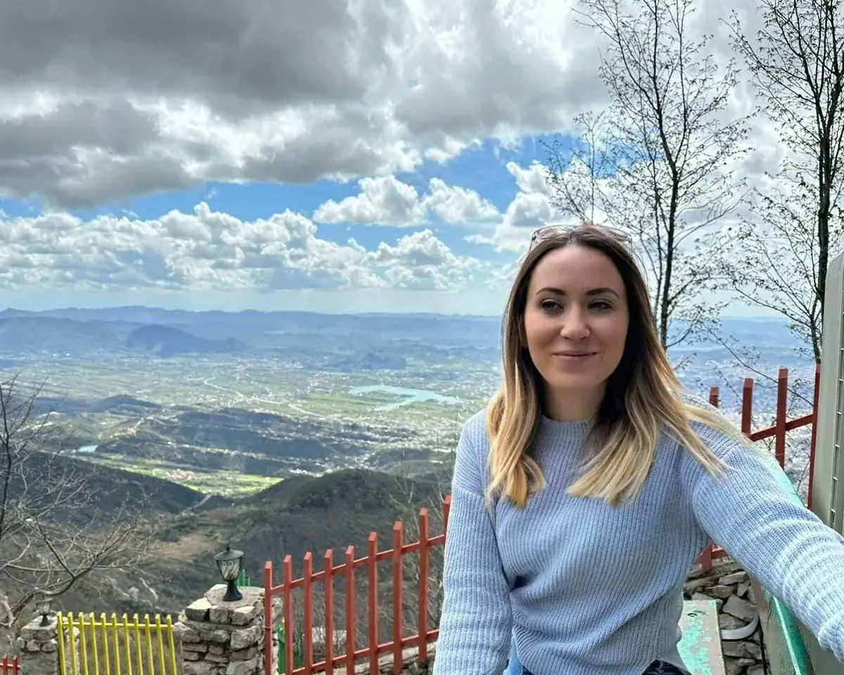 Ester Cane, licensed local tour guide, at a mountain viewpoint above the Tirana valley