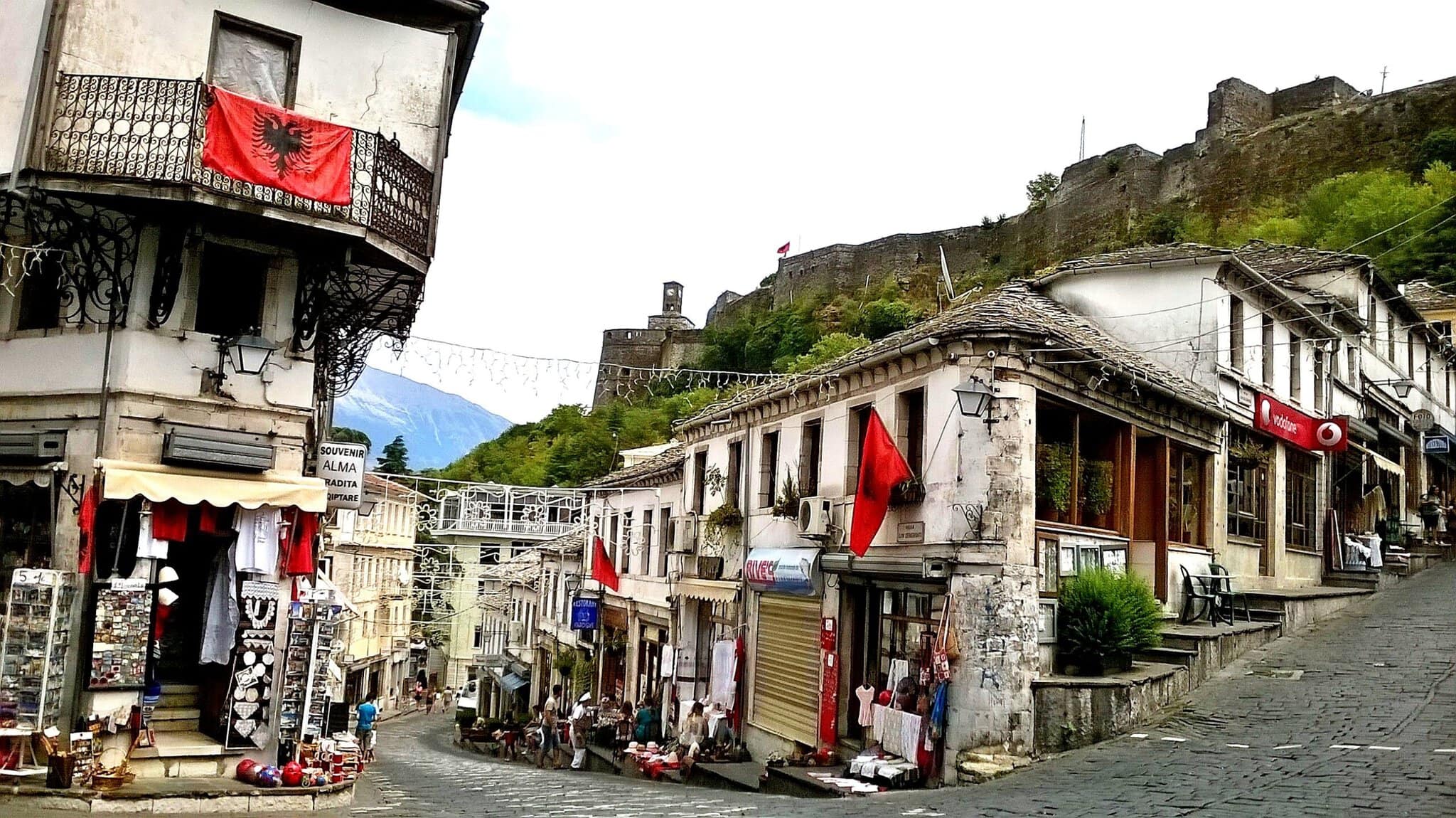 A cobbled street lined with two- and three-story stone buildings in Gjirokastra's Old Bazaar district