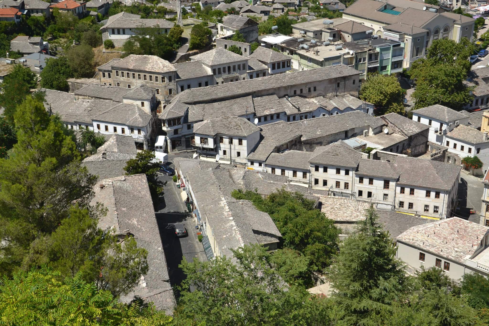 Elevated view of Gjirokastra's densely packed stone-roofed houses climbing the hillside below the fortress