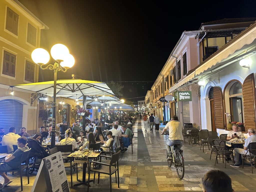 Night view of the covered bazaar arcades in Shkodra with people walking
