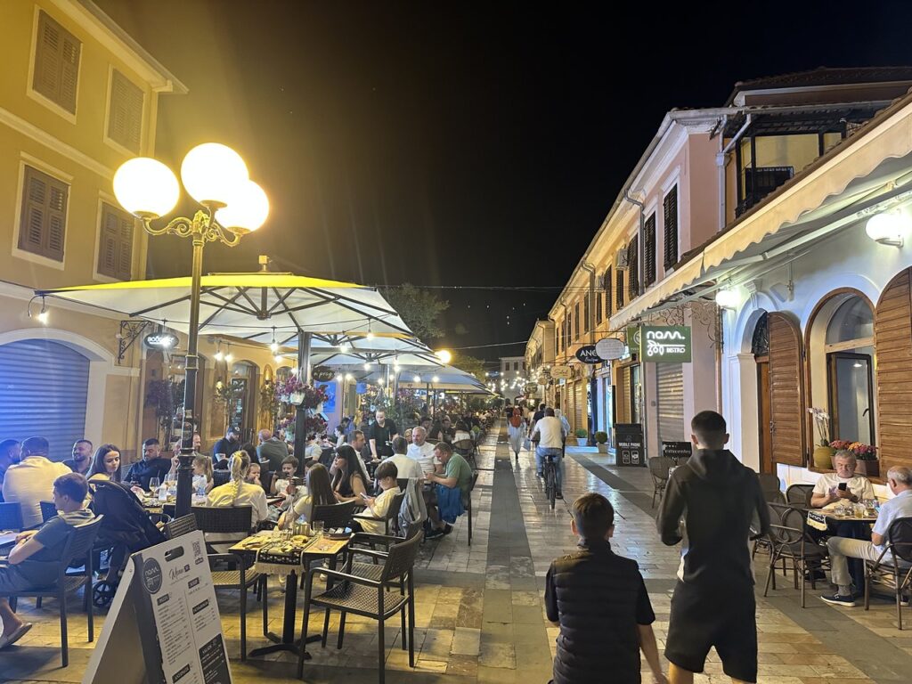 The Shkodra bazaar lit up at night with people socialising