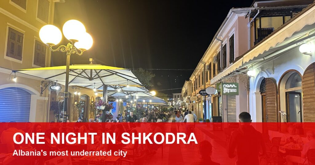 Shkodra pedestrian boulevard at night with cafes and street lamps